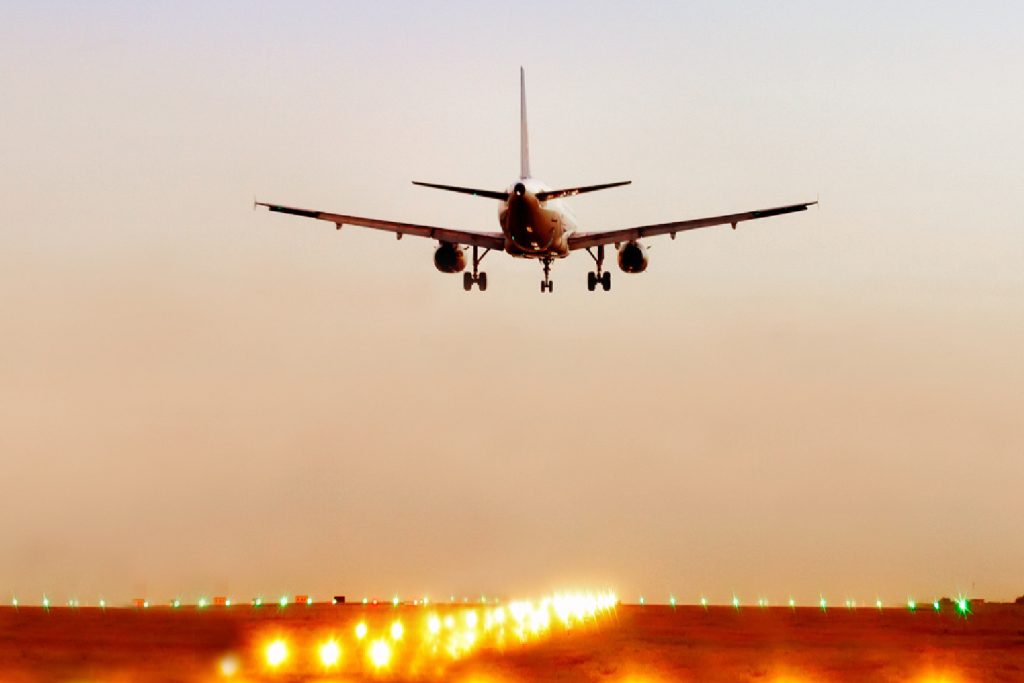 Airplane landing on illuminated runway