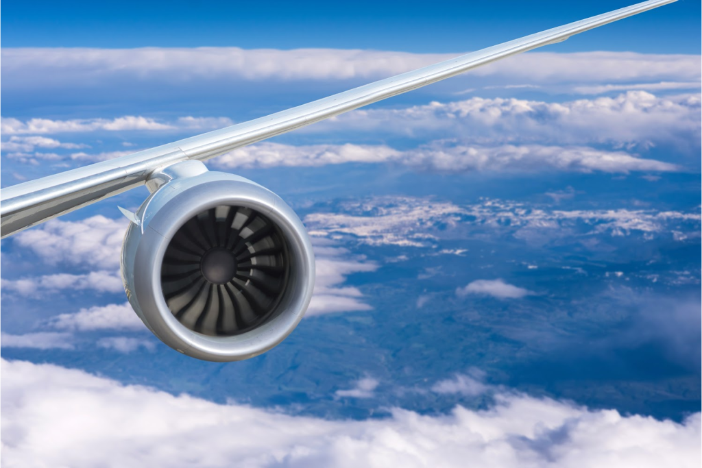 Airplane wing above fluffy clouds